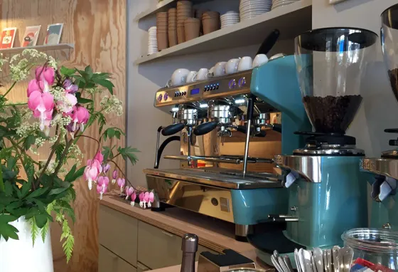 Innenansicht der Kaffeebar von buchbar Erfurt mit Kaffeemaschine, Blumen und Thekenbereich