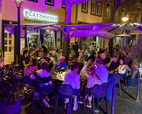 Gäste sitzen abends auf einer Restaurantterrasse beim Esstival